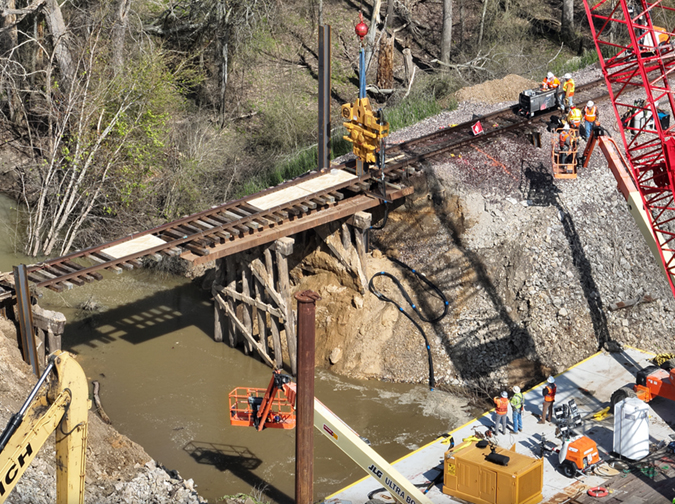 Crews work to replace a washed-out culvert with a bridge. Crews work to replace a washed-out culvert with a bridge.